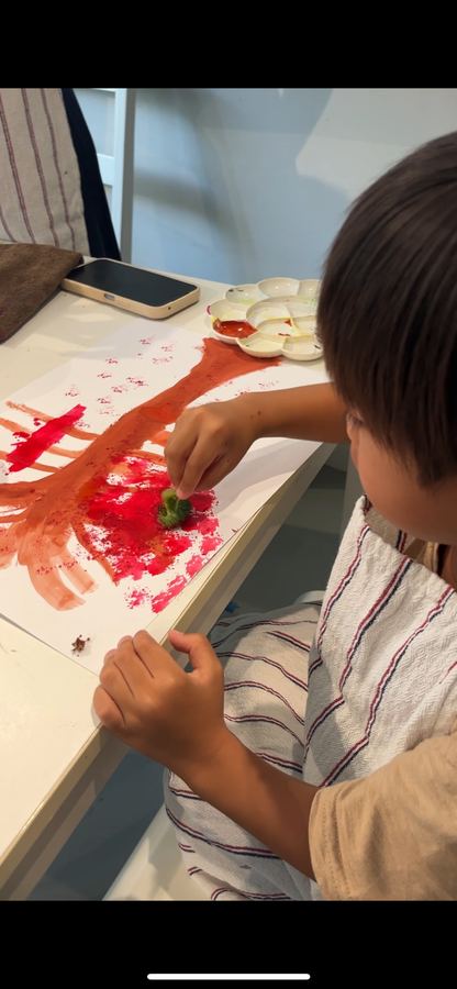 A student using a vegetable stamp technique in art class