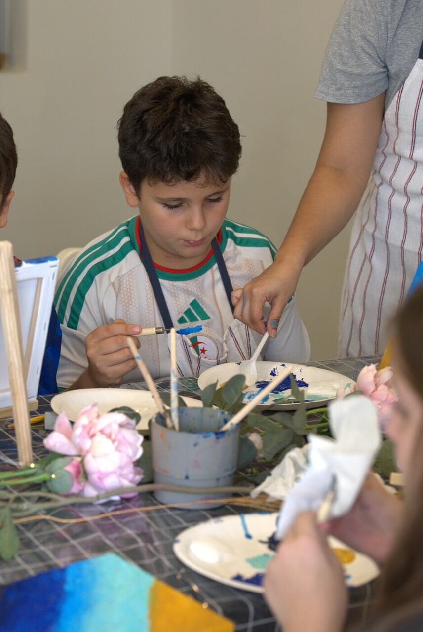 A young painter being guided through the Golden Shores technique at the workshop